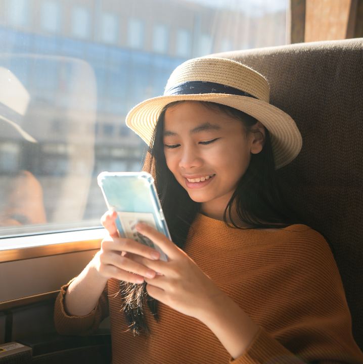 A woman uses her phone while riding on a charter bus