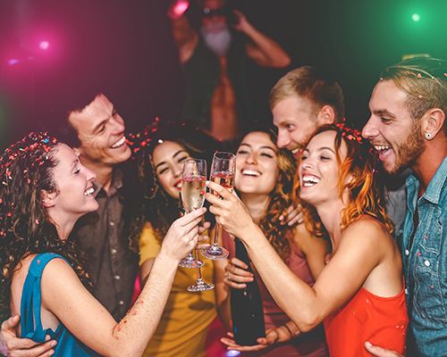 A crowd of party goers toast drinks